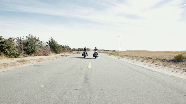 两个人骑着摩托车沿路而行视频素材
