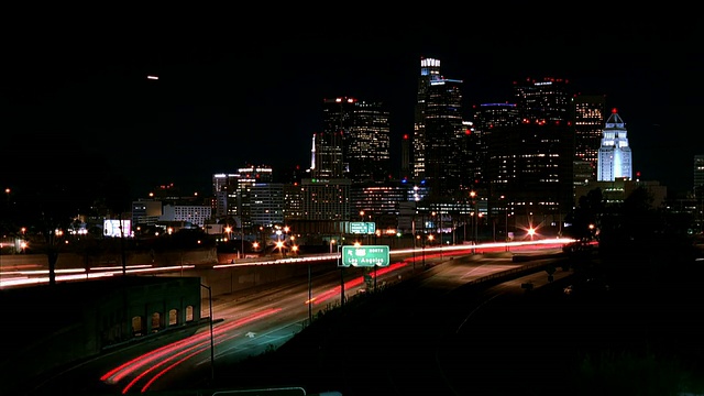 T/L, WS，夜间高速公路上的交通，背景中的城市景观，美国加州洛杉矶视频素材