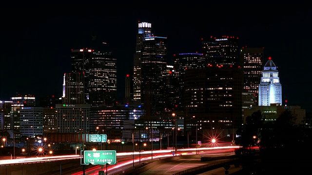 T/L, WS，夜间高速公路上的交通，背景中的城市景观，美国加州洛杉矶视频素材