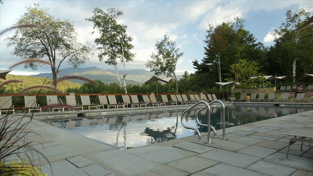 旅馆度假旅馆游泳池游泳池甲板椅子花植物视频素材