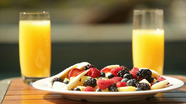 酒店度假小屋游泳池甲板甲板椅子早餐水果碗橙汁假日度假胜地视频素材