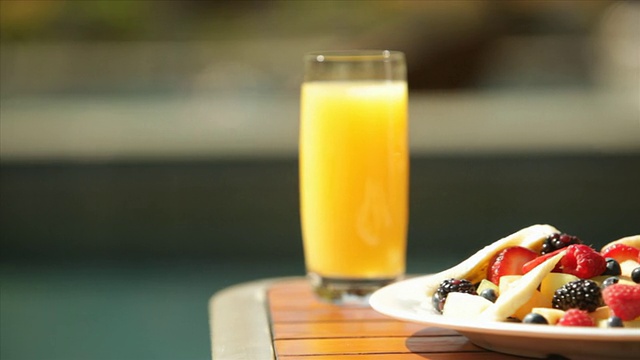 酒店度假小屋游泳池甲板甲板椅子早餐水果碗橙汁假日度假胜地视频素材