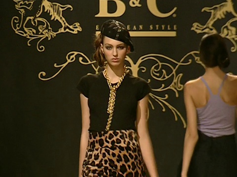 在塞尔维亚贝尔格莱德的B&C欧洲风格时装秀上，当男女模特在一排吊灯下的金箔t台上走来走去时，MS灯光亮了起来视频下载