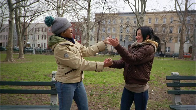 在美国纽约布鲁克林的公园/威廉斯堡，年轻女性在街上互相握手视频下载