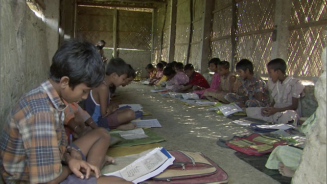 MS学校的孩子们在一间简陋的教室里坐在地上背诵课文/印度视频素材