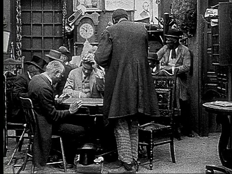 1916 B&W MS男人在扑克游戏中隐藏卡片和筹码，当男人进来和他们说话/男人站着读报纸视频下载