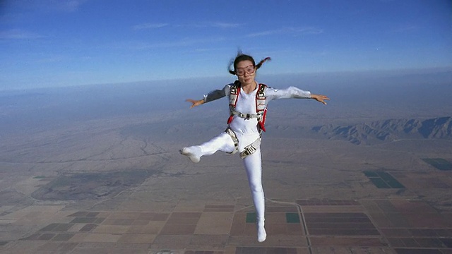 女子自由式跳伞和表演空中芭蕾在半空中拼凑景观/埃洛伊，亚利桑那州，美国视频素材