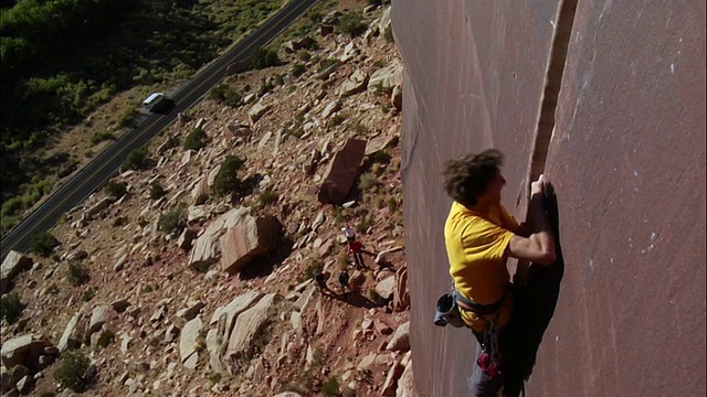 向下和对面的攀爬者攀爬平行裂缝和攀爬者卡住他的手向相机/印度溪，UT，美国视频下载