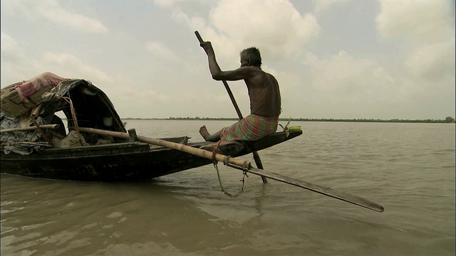 孟加拉国桑德班斯河上，WS ZI Men在小船上划桨视频下载
