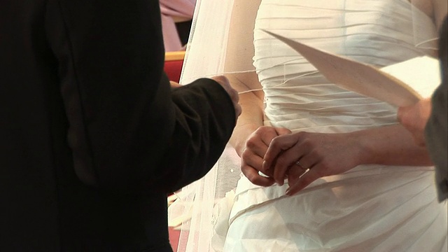 在宣誓仪式上把结婚戒指戴在新娘的手指上视频素材