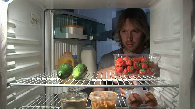 从冰箱里吃健康食品的人视频素材