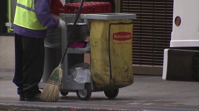 美国加州洛杉矶，一个清洁工在繁忙的人行道上捡垃圾视频素材