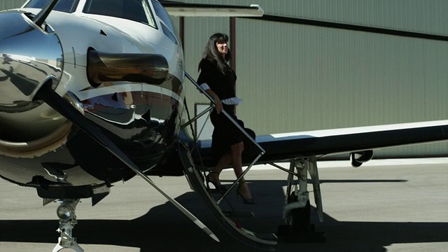 美国犹他州，女商人走下私人飞机，与一位商人握手视频素材