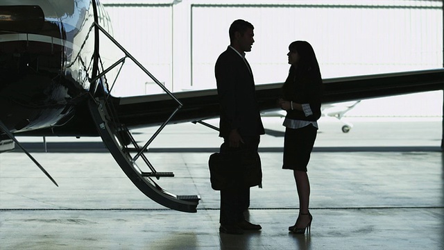 美国犹他州，在私人飞机旁边的机库里，商人和女商人在交谈视频素材