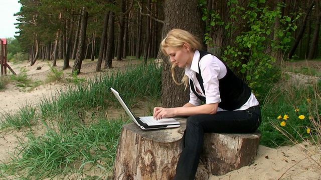 林子里拿着笔记本电脑的年轻女士视频下载