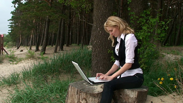 森林里带笔记本电脑的漂亮女孩视频下载