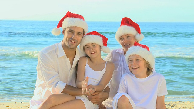 欢乐的家庭戴着圣诞帽在海滩/开普敦，西开普敦，南非视频素材