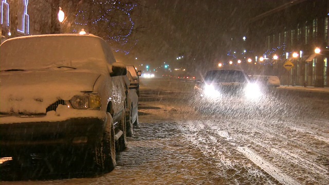 暴风雪。冬季交通。汽车在滑溜溜的路上行驶。下雪,雪花。视频素材