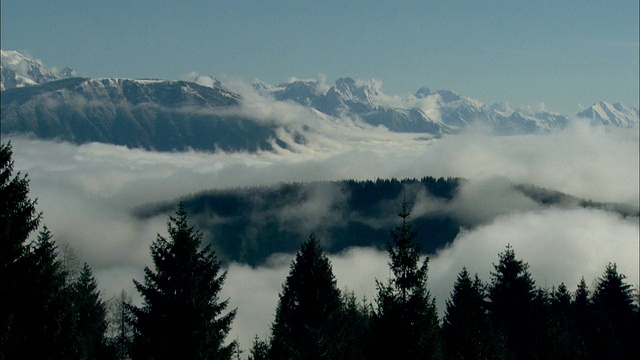 极端的长镜头静态-密云翻滚在雪山顶/意大利视频下载