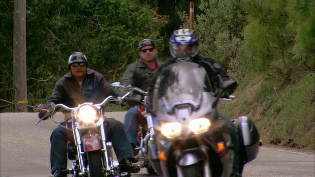 骑摩托车的人在弯弯曲曲的道路上行驶在塞拉国家森林/弗雷斯诺县，美国加利福尼亚州视频素材