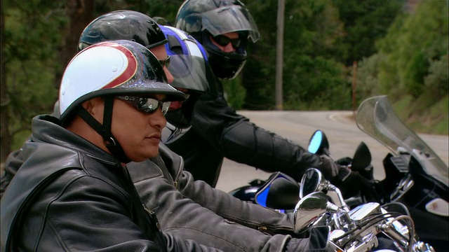 特写-骑摩托车的人驾驶摩托车在弯弯曲曲的道路在塞拉国家森林/弗雷斯诺县，美国加利福尼亚州视频素材