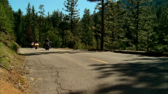 美国加利福尼亚州的塞拉国家森林/弗雷斯诺县，骑摩托车的人在路上行驶视频素材