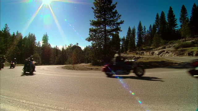美国加利福尼亚州的塞拉国家森林/弗雷斯诺县，骑摩托车的人在弯弯曲曲的道路上行驶视频素材