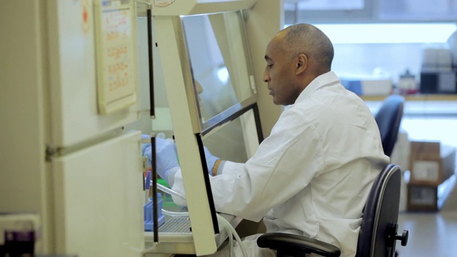 在加拿大BC省温哥华的癌症研究、医疗保健行业DNA测序实验室，CU PAN实验室技术员在通风柜中使用微型吸管视频素材