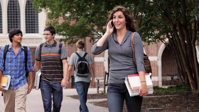 美国弗吉尼亚州里士满市，一名大学生用手机在校园里穿行视频素材