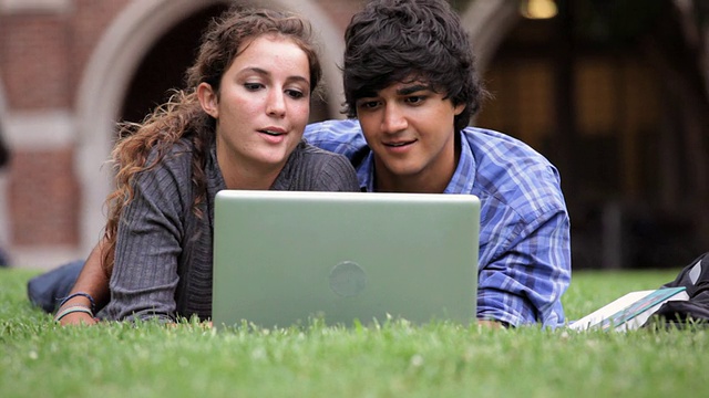 美国弗吉尼亚州里士满大学校园里，一对大学情侣用笔记本电脑开视频会议视频素材