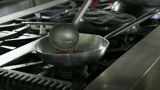 厨师把樱桃番茄放进锅里的特写镜头视频素材