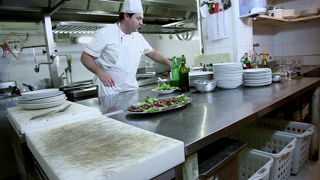 厨师把盐放在烤羊肉上的大镜头视频素材