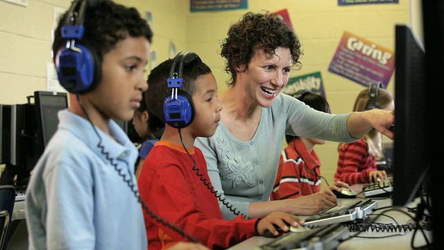 MS学生戴着耳机在计算机课上与老师/里士满，弗吉尼亚州，美国视频素材