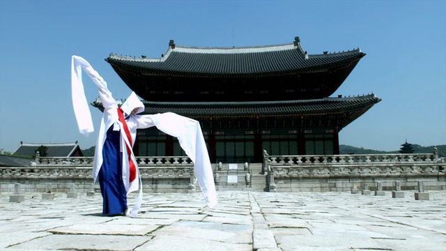 韩国首尔，一名身穿传统服饰的女子在京福宫后面表演佛教舞蹈视频素材