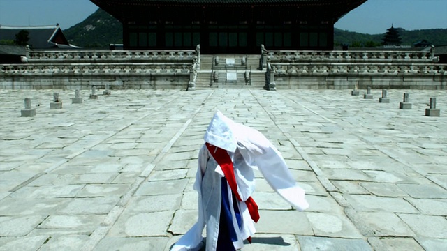 韩国首尔，身着传统服饰的ZO TU女士在京福宫后面表演佛教舞蹈视频素材