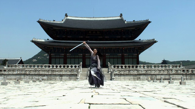 韩国首尔，京福宫后方，身着传统服饰的女子表演剑舞视频素材