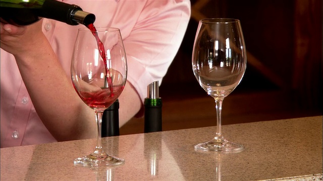 近距离的葡萄酒服务员倒两杯红酒在葡萄酒厂酒吧/ Paso Robles，美国加州视频下载