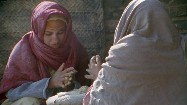 CU，重建，中东，两个女人在中世纪的乡村街道上烤面包视频素材