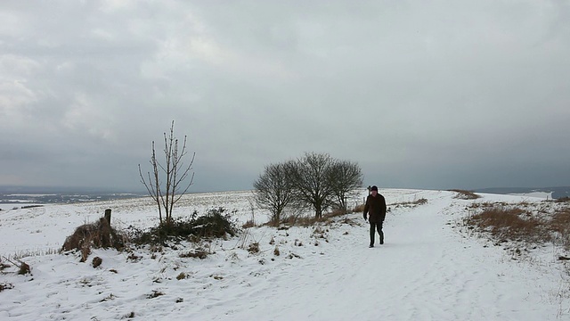 英国，一名男子在引人注目的雪景中行走视频素材