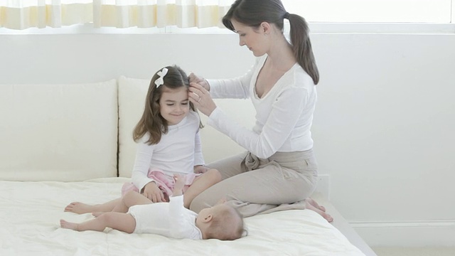 白人母亲抱着婴儿和小女孩躺在床上视频素材