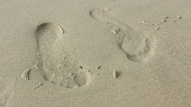 沙滩上的脚印会被海浪冲掉。视频下载