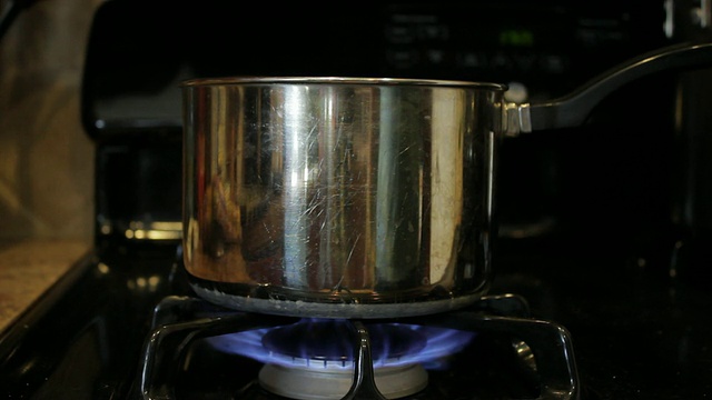 黑色煤气炉上的银锅视频素材