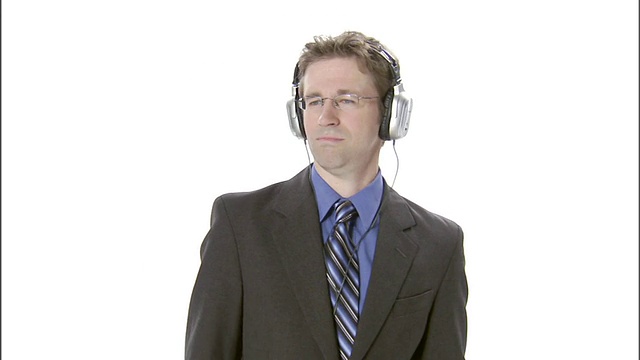 MS，商人戴着耳机在演播室里听音乐视频素材