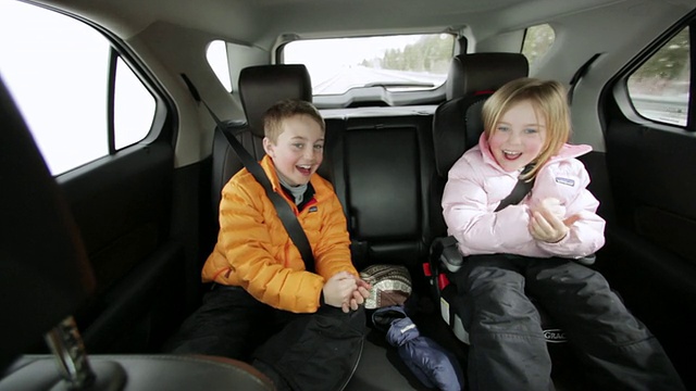 年轻的弟弟和妹妹在公路旅行的后座上玩“射击”/太阳谷，美国爱达荷州视频素材