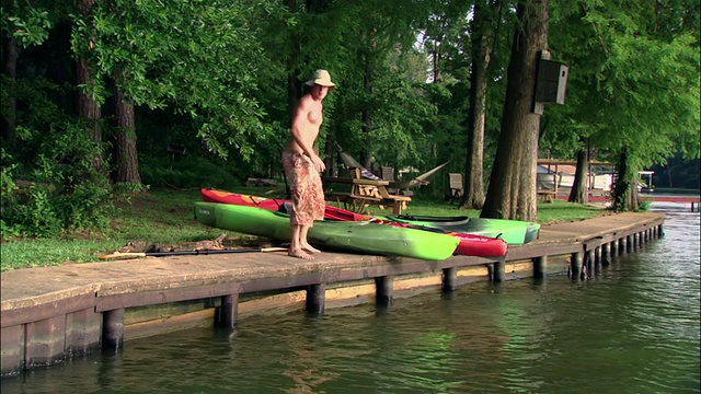 一名年轻男子在湖/德克萨斯拉皮划艇视频素材