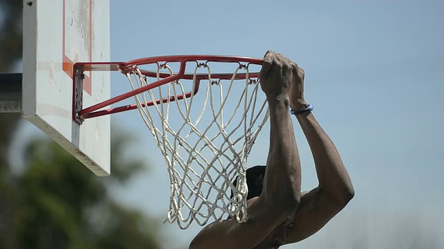 一名篮球篮板、网和篮框的CU ECU和一名黑人男性运动员反向扣篮。视频下载