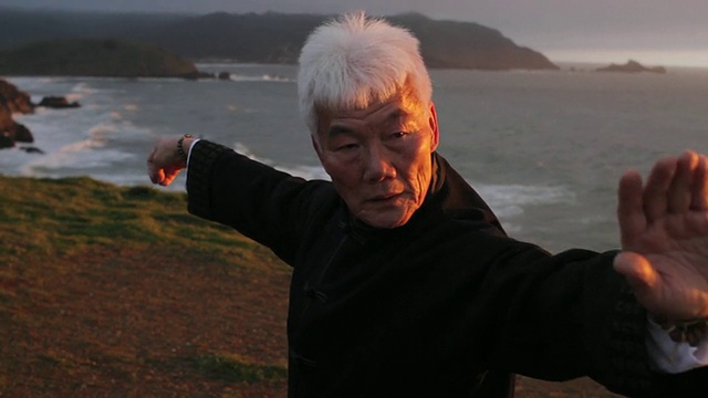 一名中国男子在美国加州太平洋的海边表演太极视频下载