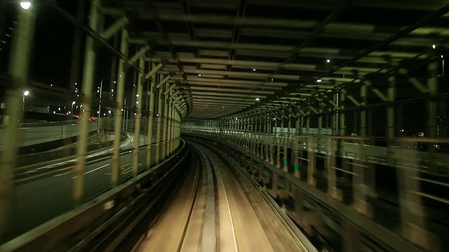 WS POV高架火车在夜晚穿过城市/日本东京视频素材