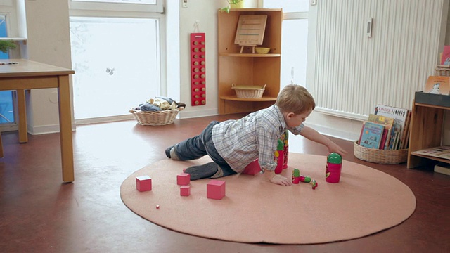 德国勃兰登堡波茨坦，MS DS Boy把立方体放在俄罗斯木制玩偶旁边的粉红色塔上视频素材