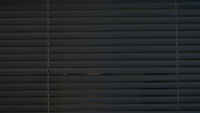 CU男子打开百叶窗向外看/新加坡视频素材